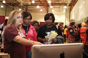 Graphic Design Technology Instructor Beth Messina points out the latest design features to Erica Adams, left, Dazieyette Jackson, center, and Talia Sweezer, right, during Eagle Experience 2016 at the Mayo Gym on the Raymond Campus Feb. 5, 2016. (April Garon/Hinds Community College)