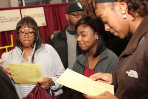 Kimberlyn Cager, left, Tyunna Odom, center foreground, and Ambriyana Roberts, right foreground, check out lists of programs featured at Eagle Experience 2016 at Mayo Gym at the Raymond Campus Feb. 5, 2016. (April Garon/Hinds Community College)