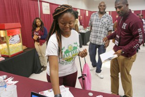 Tacora Thomas, a junior at Jim Hill High School, grabs a ping-pong ball she tossed to win a prize at College Carnival April 7 at Hinds Community College Jackson Campus-Academic/Technical Center. With her is her father, Cory Thomas, and Ahmad Smith, recruitment and outreach coordinator with the M2M program on campus. (Hinds Community College/April Garon)