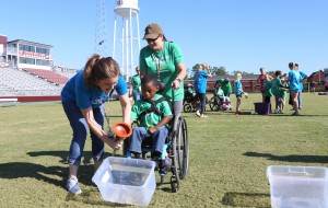 Kayden Reed, 5, a Raymond Elementary student, enjoys a team competition adding water from a plunger to the plastic bins during the “Let Your Light Shine On” special education field day at Hinds Community College. (Hinds Community College/April Garon)