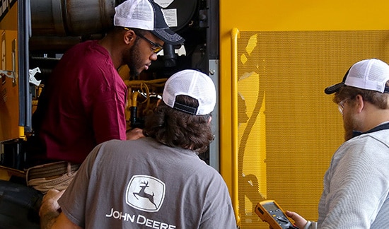 three students working on diesel engine